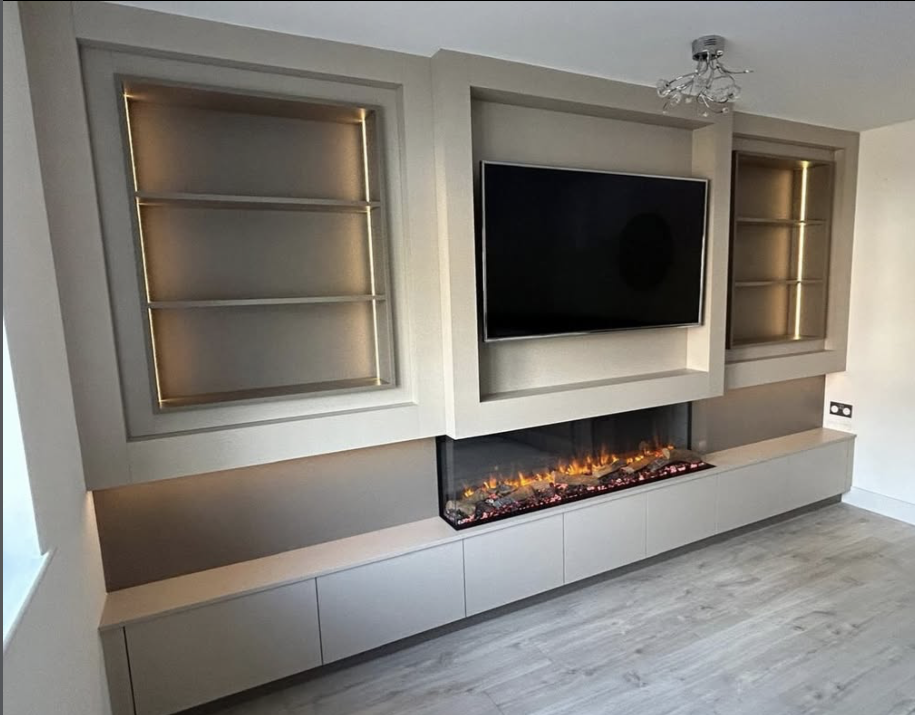 Fitted media wall with fireplace and lit display shelving