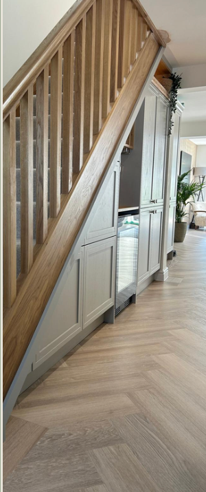 Fitted storage cabinetry beneath a staircase